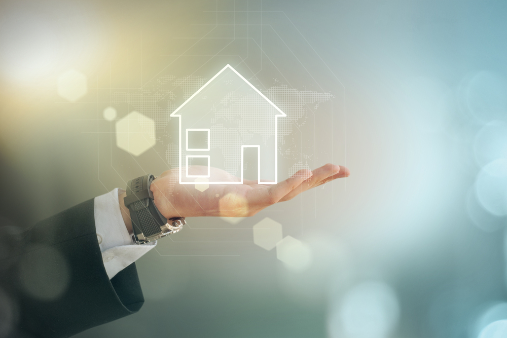 Man holding image of a home in the palm of his hand