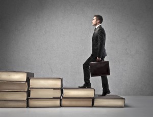 Man stepping up steps made of books